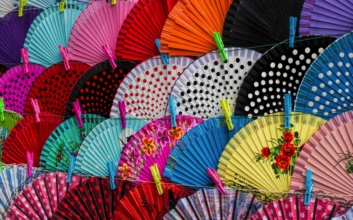 Bunte Fächer in verschiedenen Farben und Mustern aneinandergereiht.