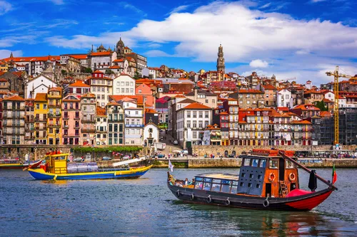 Boote auf dem Fluss vor der bunten Skyline von Porto, Portugal.