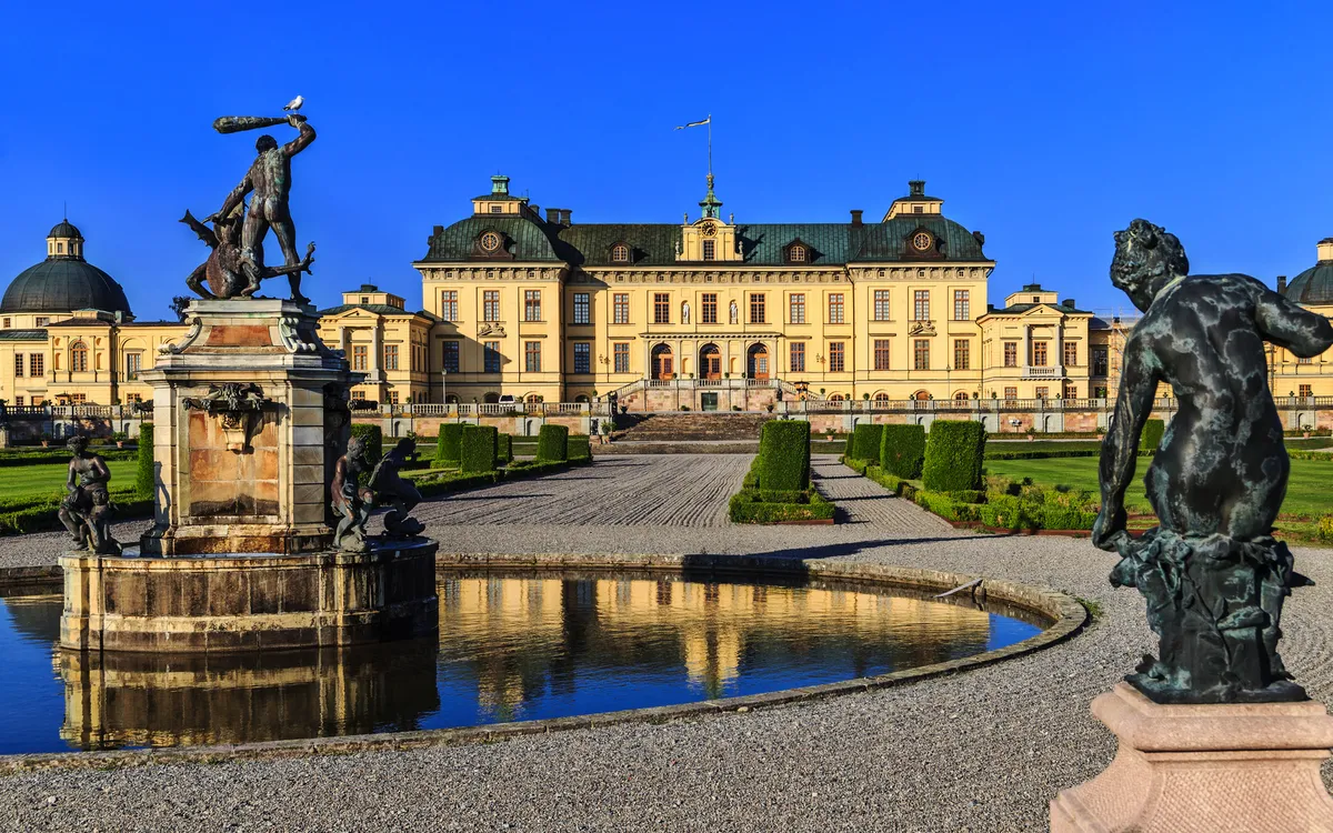 Schloss Drottningholm mit Brunnen und Statuen im Vordergrund an einem sonnigen Tag
