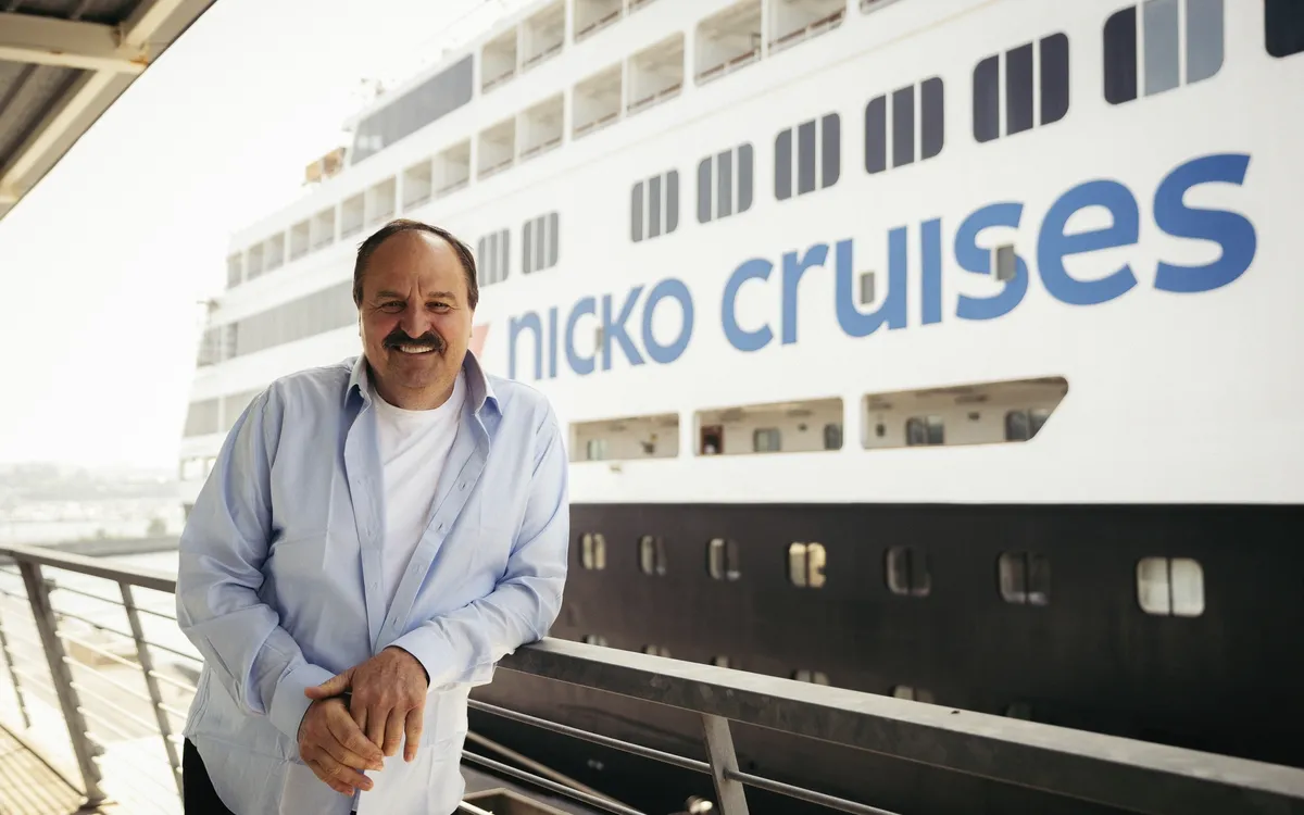 Person vor dem Kreuzfahrtschiff Vasco da Gama von Nicko Cruises.