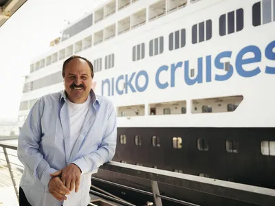 Person vor dem Kreuzfahrtschiff Vasco da Gama von Nicko Cruises.