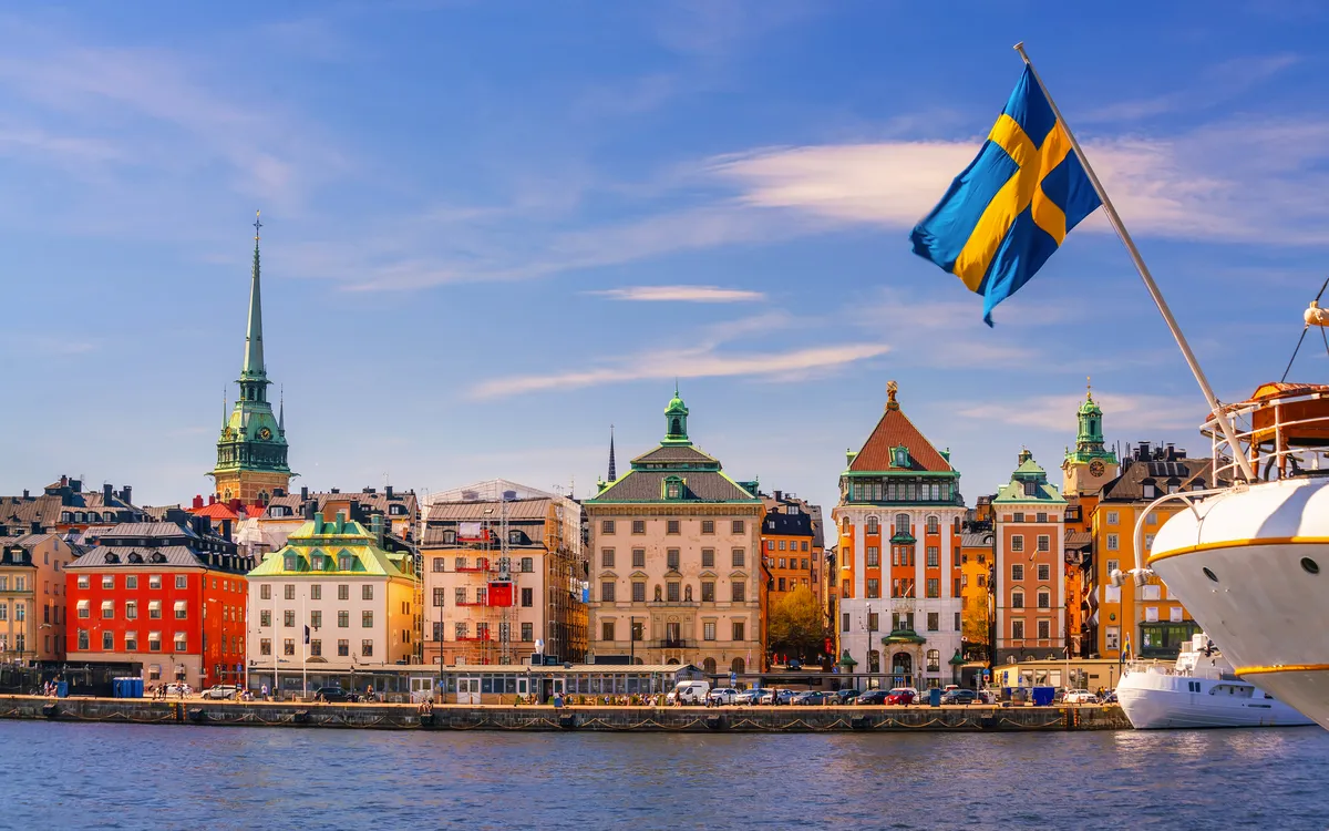 Sicht auf Gamla Stan in Stockholm mit schwedischer Fahne im Sommer.