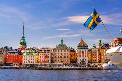 Sicht auf Gamla Stan in Stockholm mit schwedischer Fahne im Sommer.