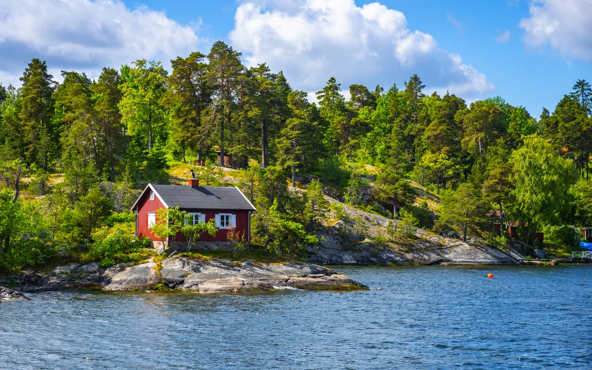 Kleine rote Hütte an skandinavischer Küste im Stockholmer Schärengarten.