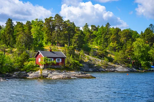 Kleine rote Hütte an skandinavischer Küste im Stockholmer Schärengarten.