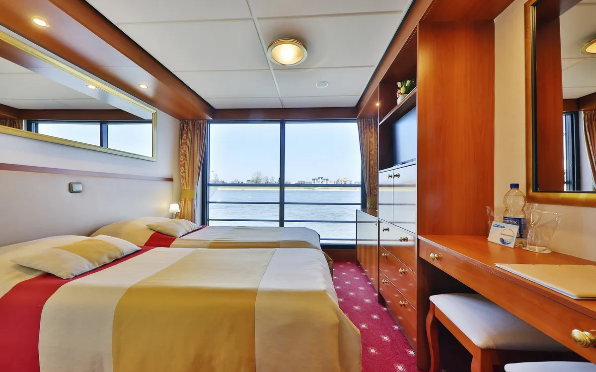 Kabine auf Kreuzfahrtschiff mit Doppelbett und Blick auf das Wasser