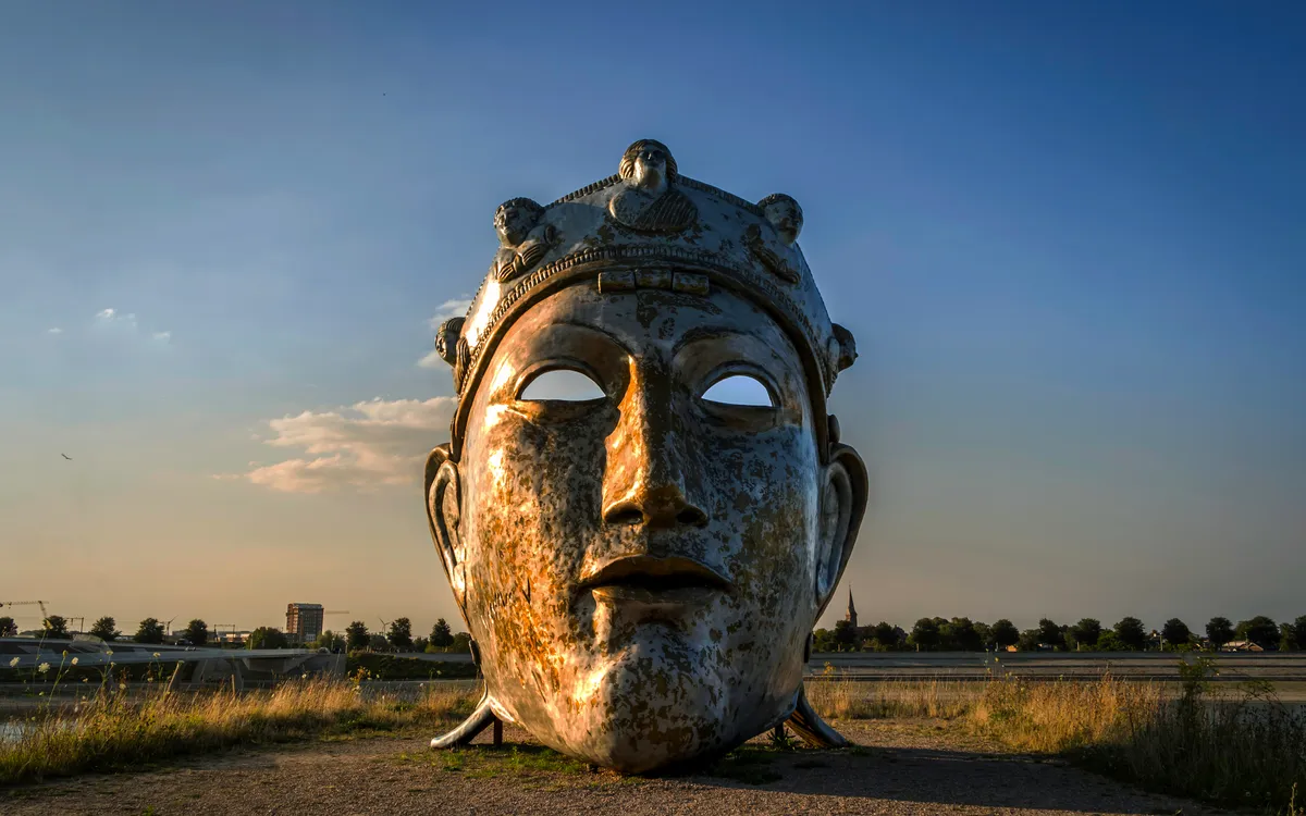 Eine große Skulptur eines Gesichtes bei Sonnenuntergang in Nijmegen.