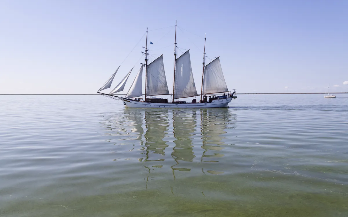 Segelschiff im Außenhafen von Enkhuizen bei ruhigem Wasser und klarem Himmel.