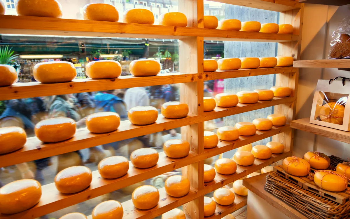 Regale mit gestapelten Goudakäse-Laiben in einem Geschäft in Alkmaar.