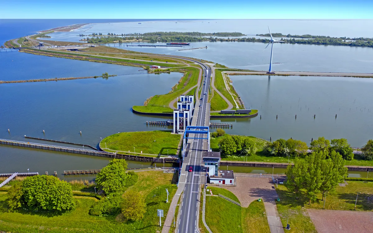 Luftaufnahme eines Deichs zwischen Enkhuizen und Lelystad, Niederlande, mit Wasserflächen.