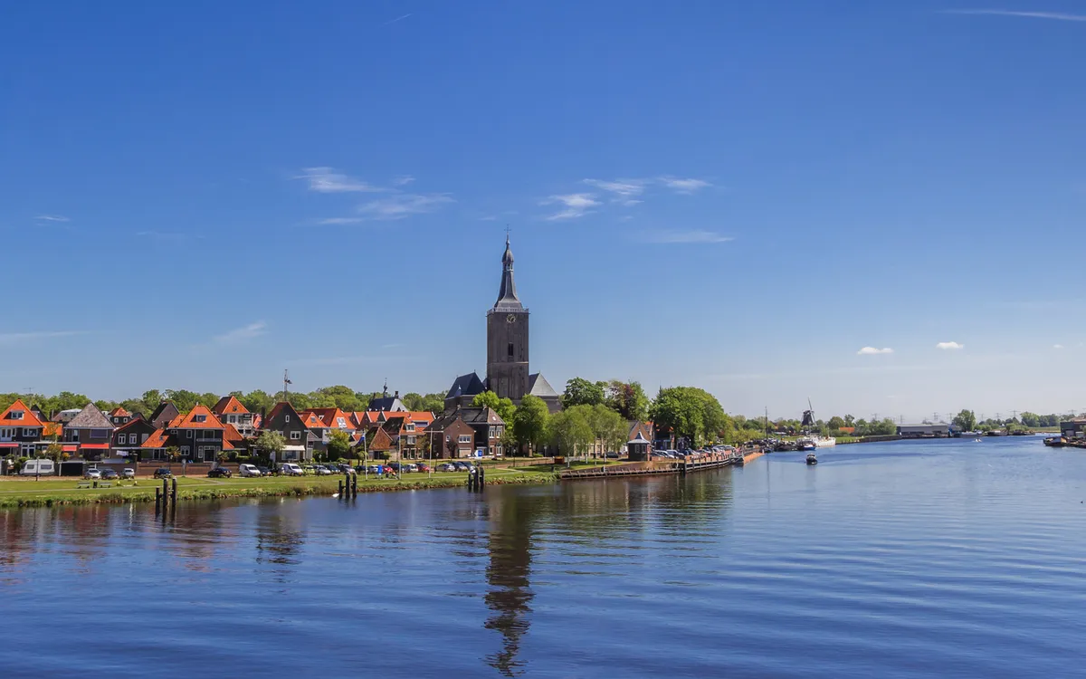 Panorama von Hasselt mit Kirchturm und Fluss bei klarem Himmel