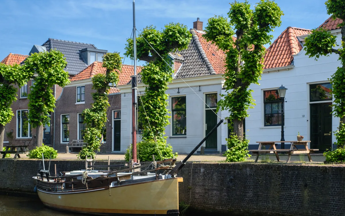 Boot auf der Herengracht in Hasselt umgeben von historischen Häusern und Bäumen.
