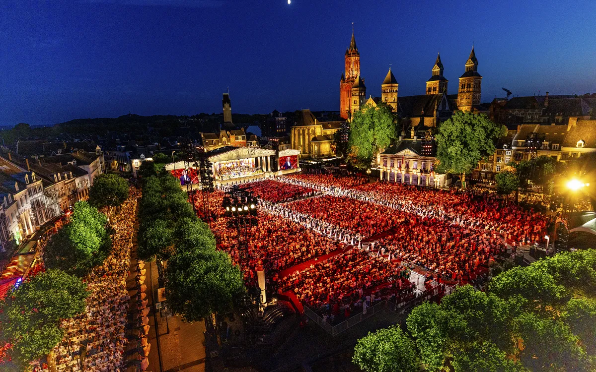 Open-Air-Konzert auf dem Vrijthof in Maastricht bei Nacht mit großer Menschenmenge.