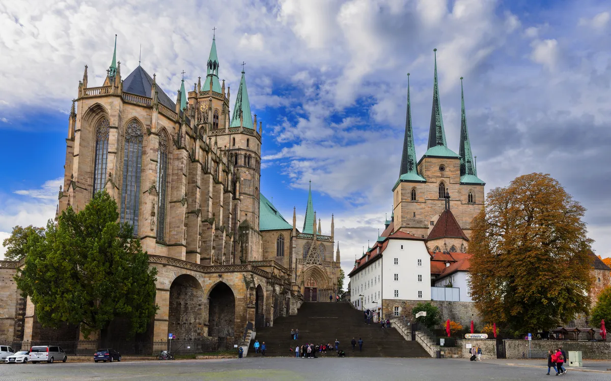 Historische Kirche mit hohen Türmen und blauem Himmel im Hintergrund.