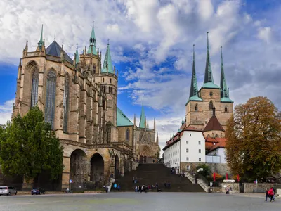 Historische Kirche mit hohen Türmen und blauem Himmel im Hintergrund.