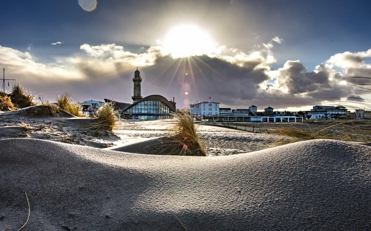 Warnemünder Leuchtturm und Teepot bei Sonnenuntergang, Ostsee-Strand im Vordergrund