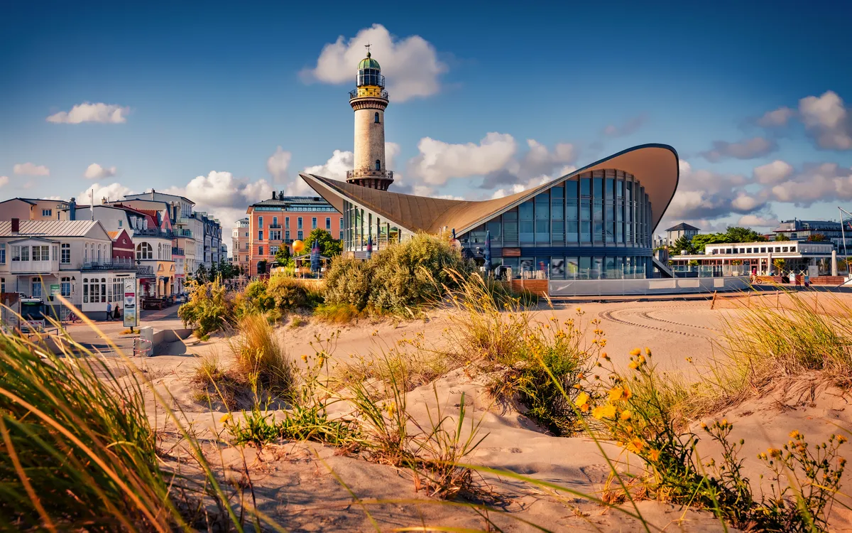 Teepot und Leuchtturm in Warnemünde am Strand an der Ostsee im Sommer.